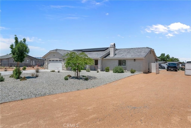 21044 Wisteria St, Apple Valley, CA 92308 - single story home featuring roof mounted solar panels, a chimney, a garage, stucco siding, and a tile roof