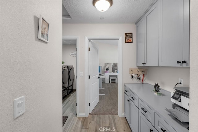 21044 Wisteria St, Apple Valley, CA 92308 - corridor with light wood-type flooring, washing machine and dryer, and a textured ceiling