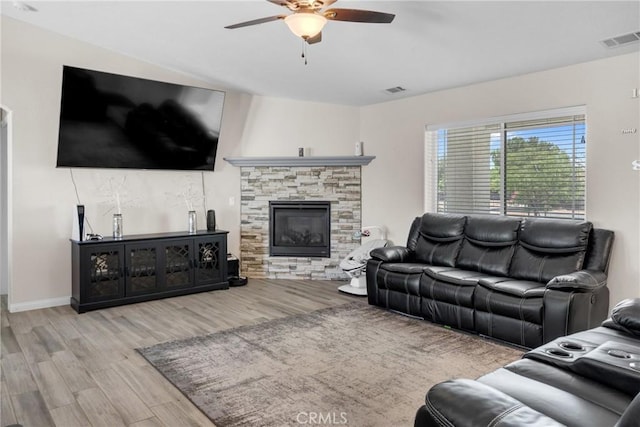 21044 Wisteria St, Apple Valley, CA 92308 - living room with ceiling fan, wood finished floors, a stone fireplace, and baseboards