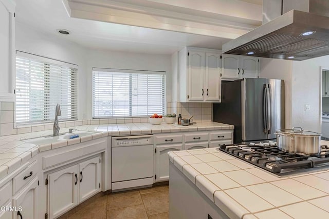 14000 Castlemaine Ave, Bakersfield, CA 93314 - kitchen with wall chimney exhaust hood, appliances with stainless steel finishes, tasteful backsplash, and white cabinetry