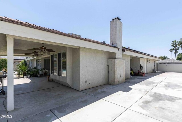 14000 Castlemaine Ave, Bakersfield, CA 93314 - back of property with a patio, ceiling fan, a chimney, and stucco siding