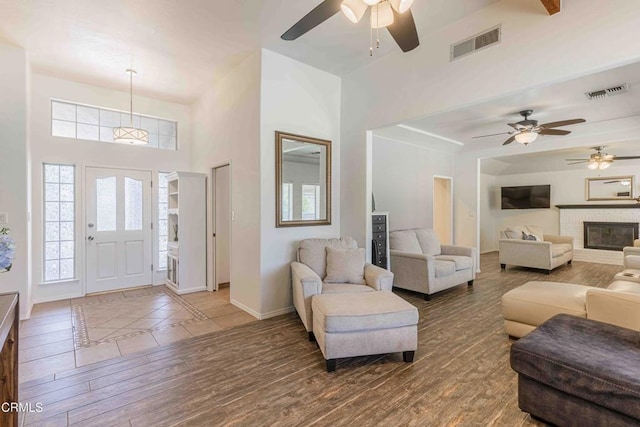 14000 Castlemaine Ave, Bakersfield, CA 93314 - living room with a ceiling fan, wood finished floors, a towering ceiling, and a brick fireplace