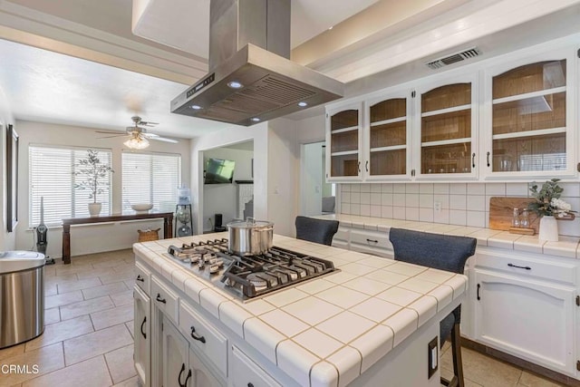 14000 Castlemaine Ave, Bakersfield, CA 93314 - kitchen featuring island range hood, tile counters, and stainless steel gas cooktop