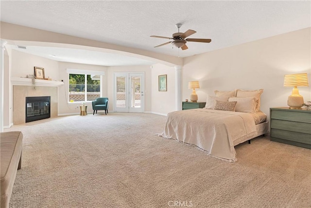 19410 Allegheny Ct, Apple Valley, CA 92307 - carpeted bedroom with decorative columns, a tile fireplace, a textured ceiling, baseboards, and access to exterior