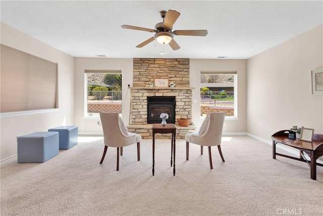 19410 Allegheny Ct, Apple Valley, CA 92307 - carpeted living area featuring healthy amount of natural light, baseboards, a stone fireplace, and a ceiling fan