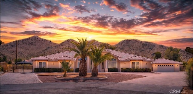 19410 Allegheny Ct, Apple Valley, CA 92307 - mediterranean / spanish home featuring a mountain view, a tiled roof, a garage, and concrete driveway