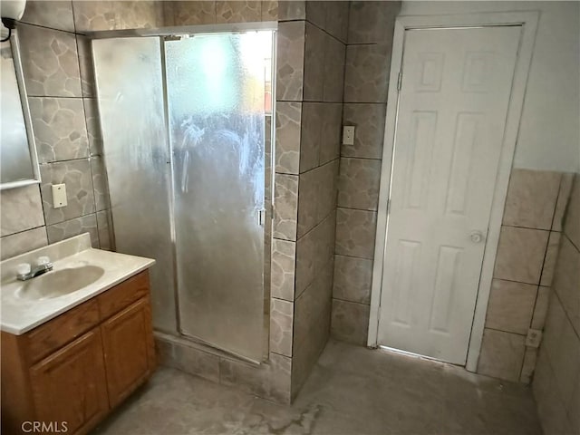 4639 Flora St, Montclair, CA 91763 - bathroom featuring vanity, a shower stall, and tile walls