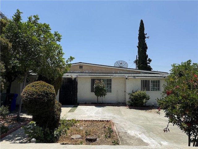 4639 Flora St, Montclair, CA 91763 - view of front of home featuring stucco siding, solar panels, and a patio area