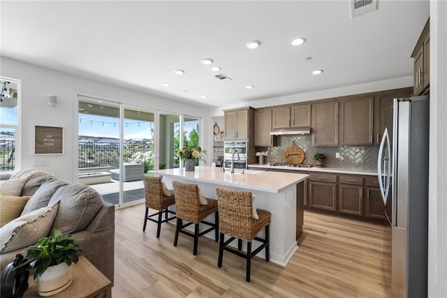 32325 Hillstone St, Temecula, CA 92591 - kitchen with stainless steel appliances, healthy amount of natural light, open floor plan, under cabinet range hood, and recessed lighting