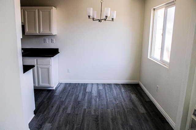 188 S Lincoln Ave Unit 22, El Cajon, CA 92020 - unfurnished dining area featuring a chandelier, dark wood-type flooring, and baseboards