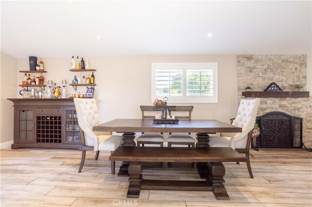 27573 Santa Clarita Rd, Saugus, CA 91350 - dining space featuring light wood-type flooring, a bar, and a stone fireplace