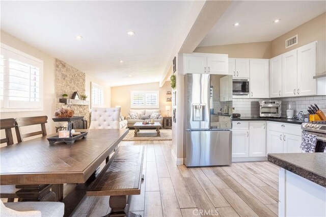 27573 Santa Clarita Rd, Saugus, CA 91350 - kitchen featuring stainless steel appliances, dark countertops, white cabinetry, decorative backsplash, and recessed lighting