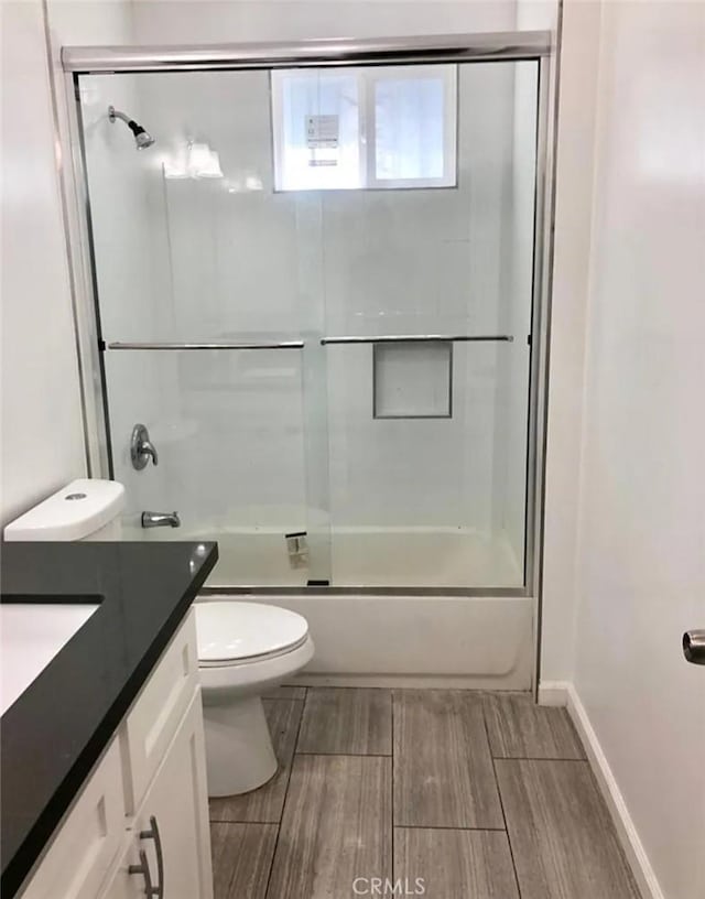 352 W Peach St, Compton, CA 90222 - bathroom featuring vanity, toilet, wood finish floors, bath / shower combo with glass door, and baseboards