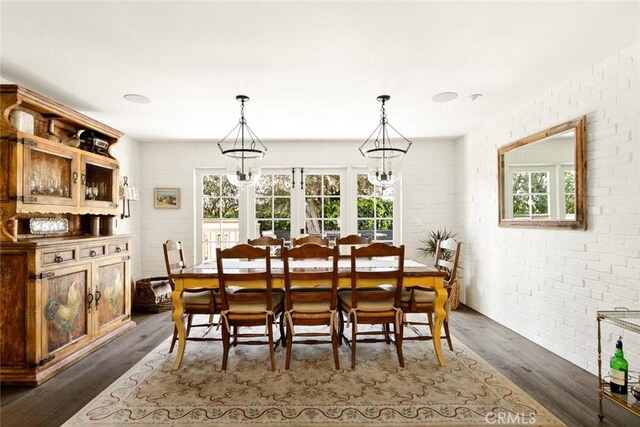 326 Ruby St, Laguna Beach, CA 92651 - dining area featuring brick wall, dark wood finished floors, and a chandelier