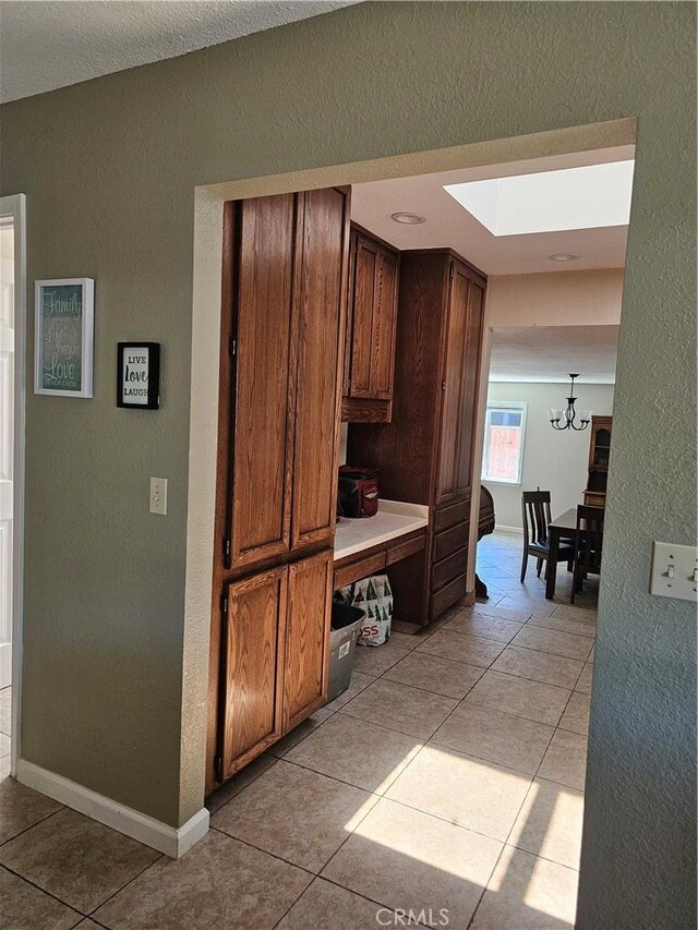 1371 Yokayo Dr, Ukiah, CA 95482 - kitchen featuring a textured wall, a chandelier, light tile patterned flooring, a skylight, and light countertops