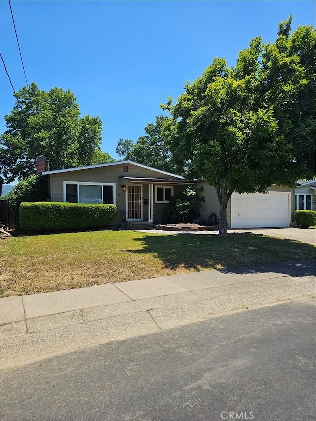 1371 Yokayo Dr, Ukiah, CA 95482 - view of front facade with a front yard, concrete driveway, a chimney, and an attached garage