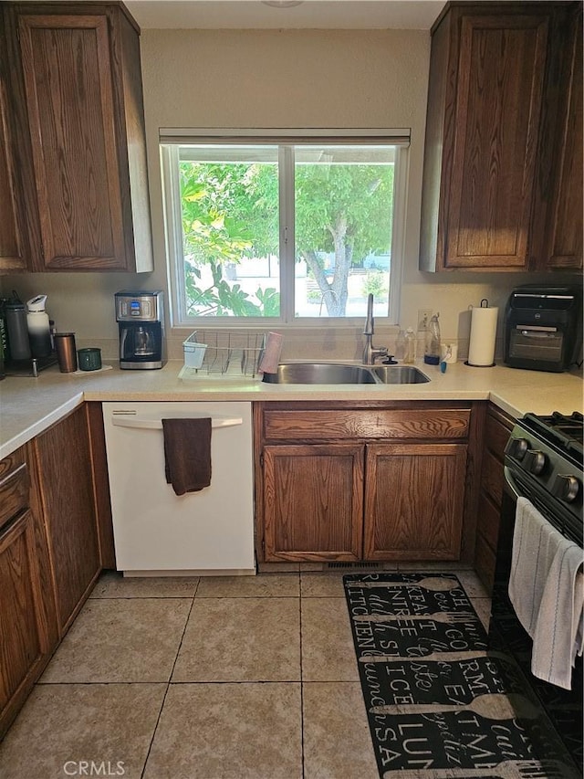 1371 Yokayo Dr, Ukiah, CA 95482 - kitchen with white dishwasher, a sink, black gas stove, light countertops, and light tile patterned flooring