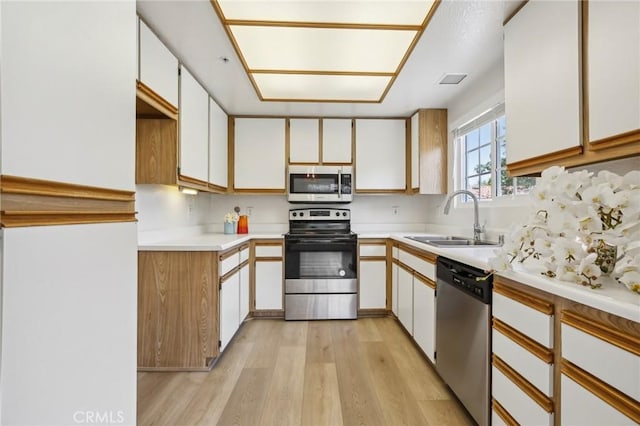 119 Gallery Way, Tustin, CA 92782 - kitchen with appliances with stainless steel finishes, a sink, light wood-type flooring, light countertops, and white cabinets
