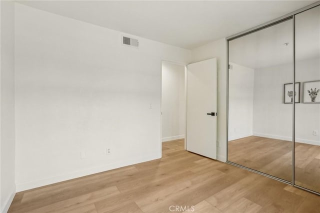 119 Gallery Way, Tustin, CA 92782 - unfurnished bedroom with wood finished floors, a closet, and baseboards