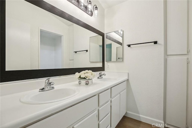 119 Gallery Way, Tustin, CA 92782 - bathroom with baseboards, double vanity, and wood finished floors