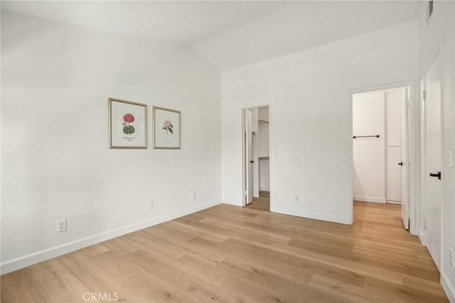 119 Gallery Way, Tustin, CA 92782 - unfurnished bedroom featuring a spacious closet, lofted ceiling, light wood finished floors, and baseboards