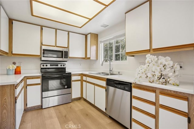 119 Gallery Way, Tustin, CA 92782 - kitchen featuring stainless steel appliances, a sink, light wood finished floors, and light countertops