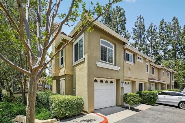 119 Gallery Way, Tustin, CA 92782 - multi unit property with stucco siding, an attached garage, and driveway