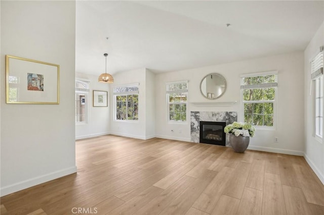 119 Gallery Way, Tustin, CA 92782 - unfurnished living room featuring light wood-style floors, baseboards, healthy amount of natural light, and a premium fireplace
