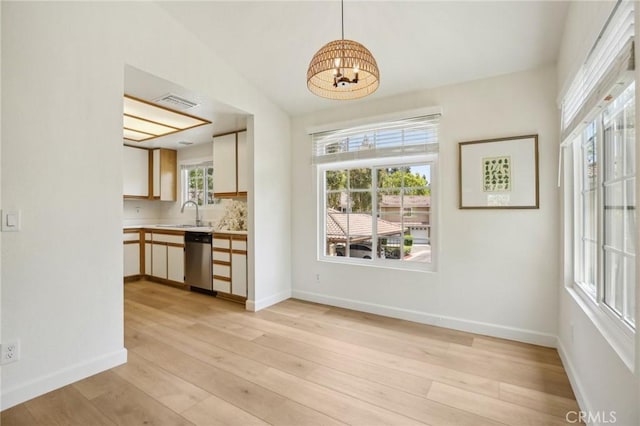 119 Gallery Way, Tustin, CA 92782 - kitchen with stainless steel dishwasher, a chandelier, light countertops, and light wood-style floors