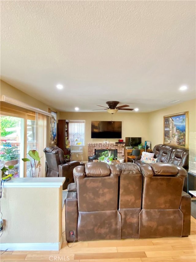 5218 Rocky Mountain Pl, Rancho Cucamonga, CA 91737 - living area featuring a ceiling fan, a textured ceiling, light wood-style floors, a fireplace, and recessed lighting