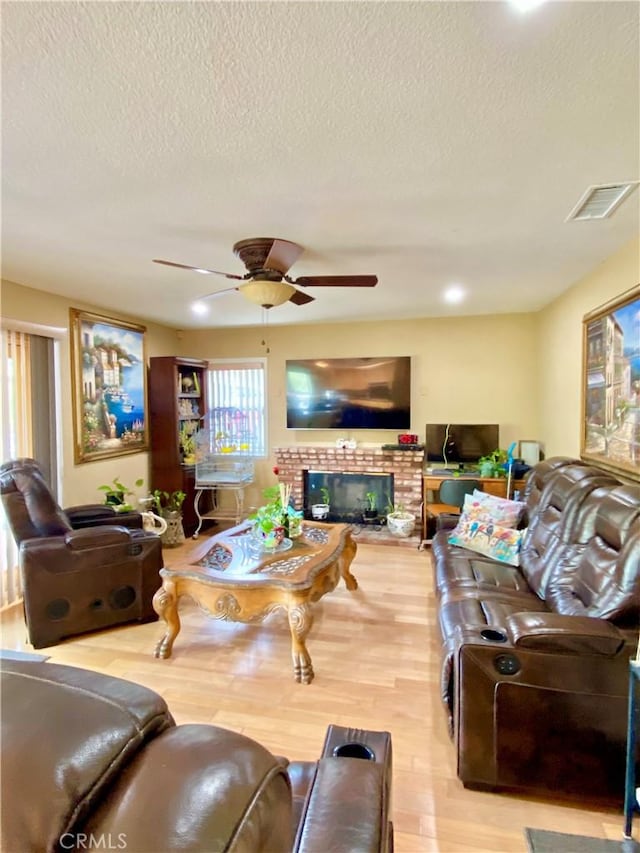 5218 Rocky Mountain Pl, Rancho Cucamonga, CA 91737 - living area featuring wood finished floors, ceiling fan, a textured ceiling, and a brick fireplace