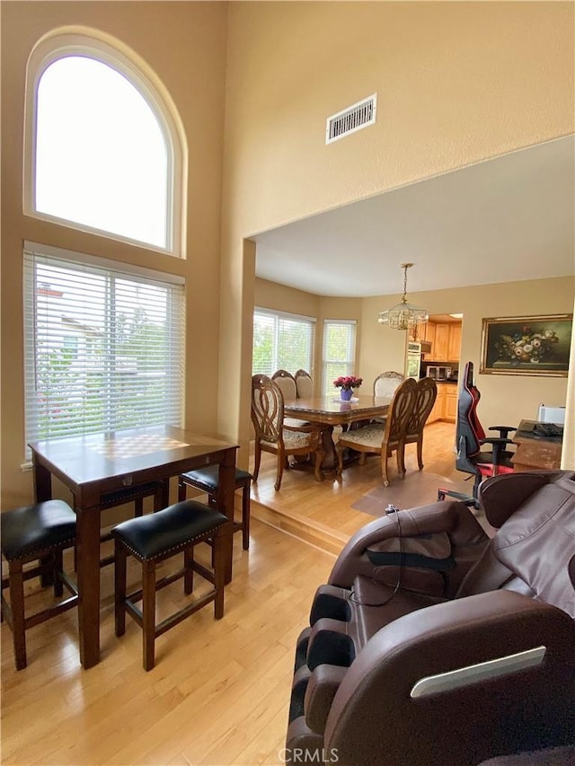 5218 Rocky Mountain Pl, Rancho Cucamonga, CA 91737 - living room featuring light wood finished floors, a high ceiling, and a chandelier