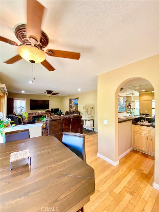 5218 Rocky Mountain Pl, Rancho Cucamonga, CA 91737 - dining space with ceiling fan, arched walkways, light wood finished floors, and a textured ceiling