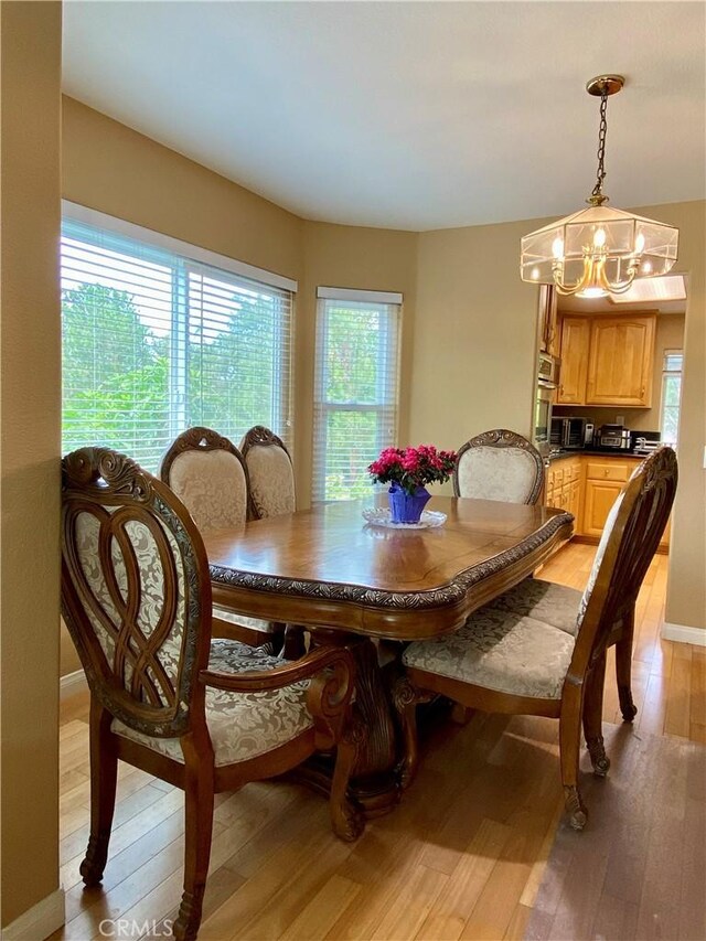 5218 Rocky Mountain Pl, Rancho Cucamonga, CA 91737 - dining area with light wood-type flooring and a chandelier