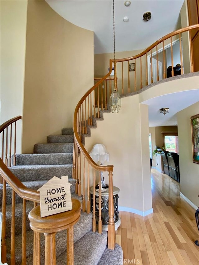 5218 Rocky Mountain Pl, Rancho Cucamonga, CA 91737 - stairway featuring wood finished floors and a high ceiling