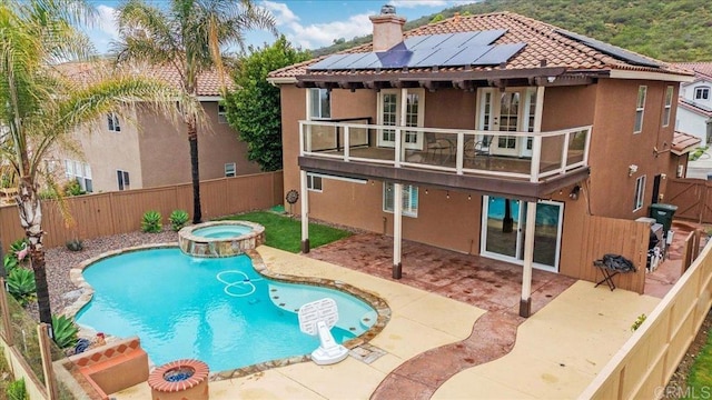 858 Via Barquero, San Marcos, CA 92069 - rear view of property with a balcony, a fenced backyard, stucco siding, roof mounted solar panels, and a patio area