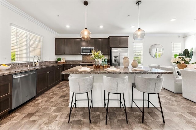 15975 Osprey Ave, Chino, CA 91708 - kitchen with appliances with stainless steel finishes, a sink, a kitchen bar, dark brown cabinetry, and ornamental molding