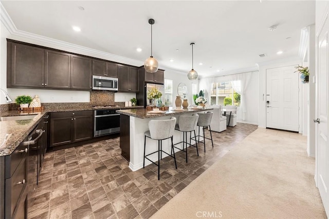 15975 Osprey Ave, Chino, CA 91708 - kitchen with stainless steel appliances, a sink, dark brown cabinets, crown molding, and a kitchen bar