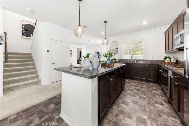 15975 Osprey Ave, Chino, CA 91708 - kitchen featuring ornamental molding, a sink, appliances with stainless steel finishes, dark stone countertops, and a kitchen island