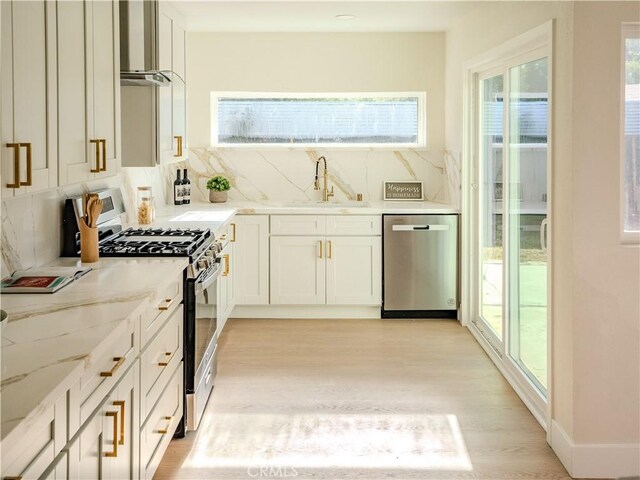8213 Ethel Ave, North Hollywood, CA 91605 - kitchen with stainless steel appliances, a sink, light wood-type flooring, decorative backsplash, and plenty of natural light