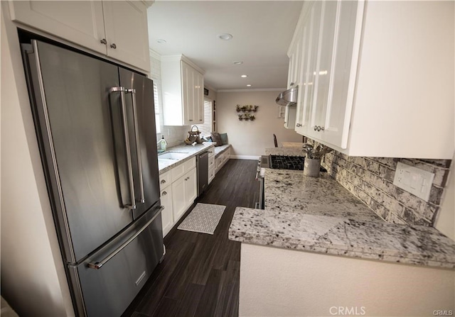 7680 Jadeite Ave, Rancho Cucamonga, CA 91730 - kitchen with appliances with stainless steel finishes, white cabinets, backsplash, dark wood-style floors, and ornamental molding