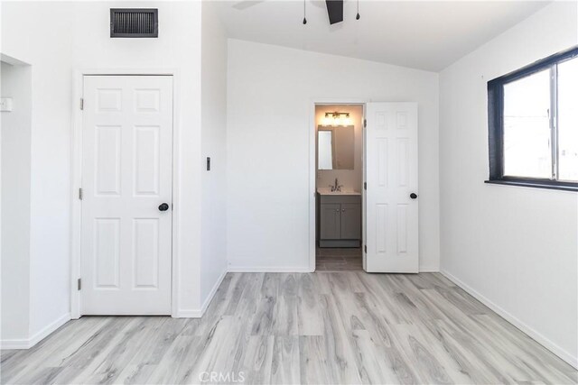 2025 Rio Vis, Needles, CA 92363 - unfurnished bedroom featuring light wood-style flooring, vaulted ceiling, a sink, baseboards, and connected bathroom