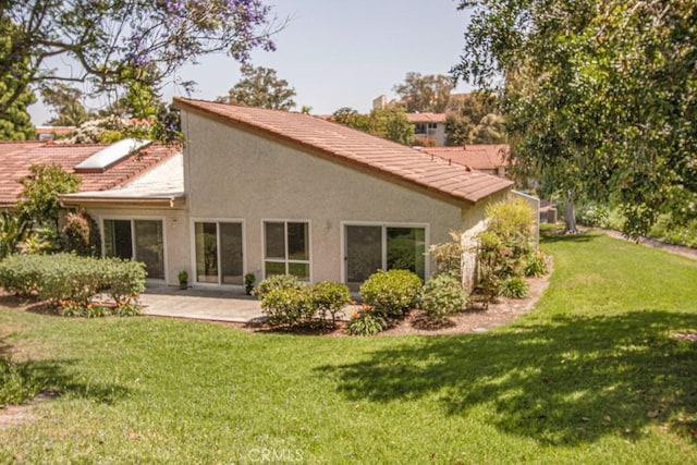 3375 Punta Alta Unit A, Laguna Woods, CA 92637 - rear view of property with a lawn, a patio area, a tile roof, and stucco siding