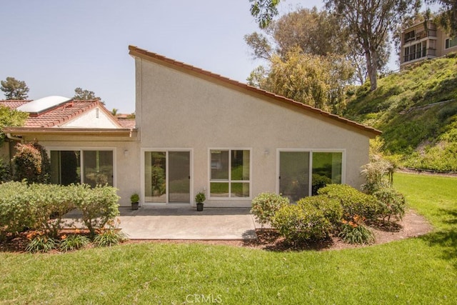 3375 Punta Alta Unit A, Laguna Woods, CA 92637 - back of house with a patio area, a lawn, stucco siding, and a tiled roof