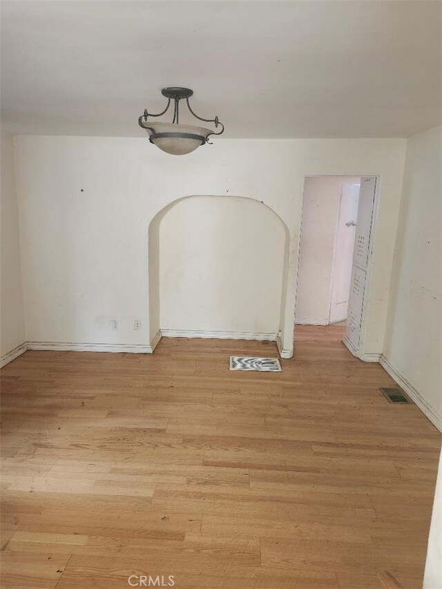 1280 E Woodbury Rd, Pasadena, CA 91104 - unfurnished dining area featuring light wood-style floors, arched walkways, and baseboards