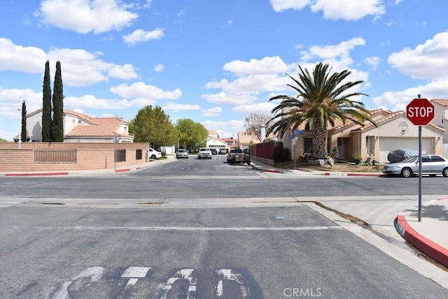 2125 Bramble Ln, Palmdale, CA 93550 - view of asphalt street featuring sidewalks, a residential view, curbs, and traffic signs