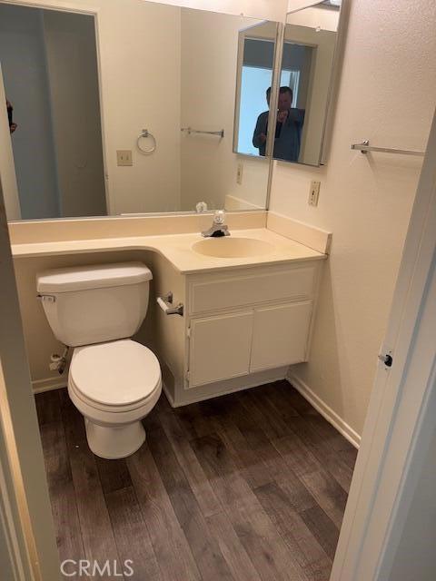 2125 Bramble Ln, Palmdale, CA 93550 - half bath featuring wood finished floors, toilet, vanity, and baseboards