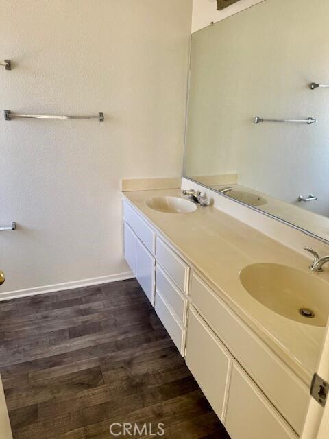 2125 Bramble Ln, Palmdale, CA 93550 - full bathroom featuring wood finished floors, double vanity, and baseboards