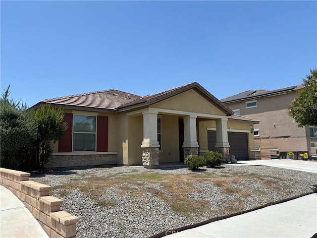 5927 Berryhill Dr, Eastvale, CA 92880 - view of front of home with stone siding, a garage, stucco siding, a tile roof, and driveway