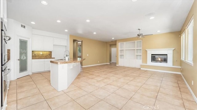 25030 Crimson Lasso Dr, Wildomar, CA 92595 - kitchen featuring light tile patterned flooring, a ceiling fan, white cabinets, recessed lighting, and a center island with sink